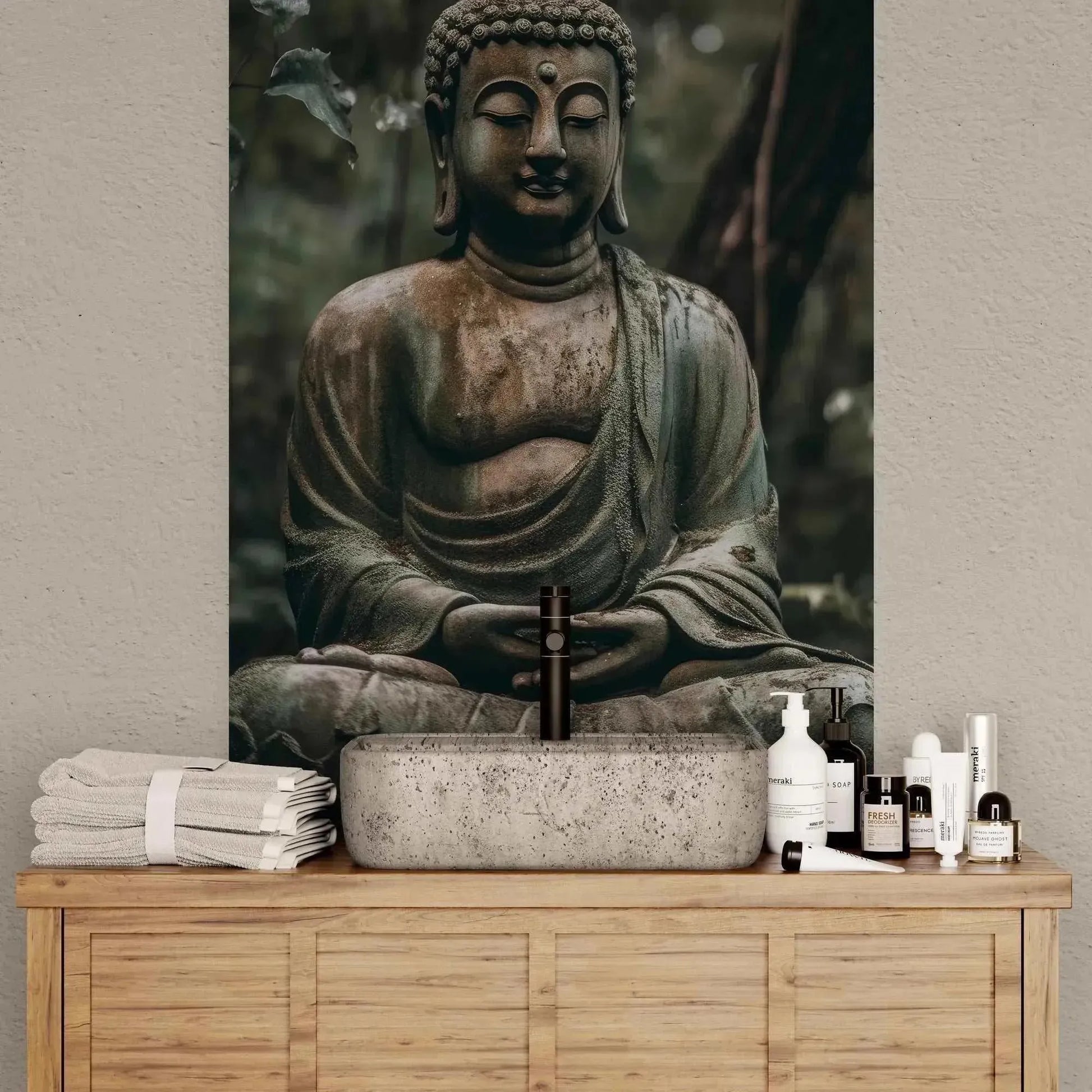 A tranquil bathroom arrangement highlights the "Buddha in Meditation" from ZenArtBliss.com's Fusion of Art and Spirituality collection by Printify as a stunning backdrop. The wooden vanity, complete with a stone sink, various toiletries, and neatly folded towels, enhances the serene, spa-like ambiance.