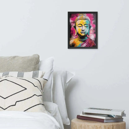 A vibrant framed poster of a stylized Modern Buddha Painting hangs on a white wall above a neatly arranged bed with plush pillows and a decorative cushion. A bedside table to the right holds a stack of books beside a white bed covered in crisp linen. A wooden tray with a black bowl and a jar rests on the bed, adding a homely touch to the modern, serene bedroom setting.