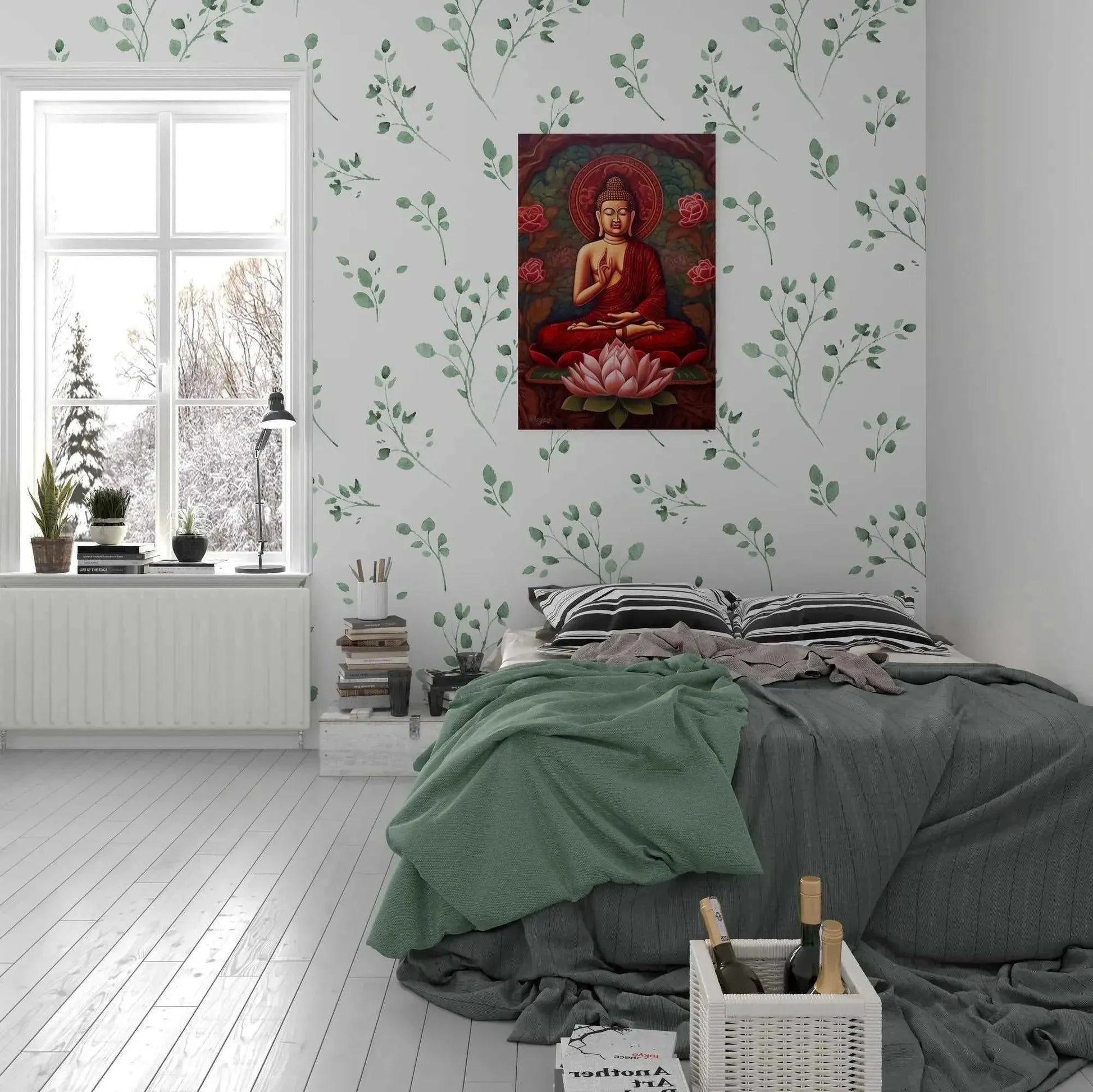 A cozy bedroom with white walls and leafy wallpaper features a bed adorned with green blankets and striped pillows next to a window offering a scenic view. Above the bed, where the painting once hung, is now the "sitting buddha print: A Striking Abstract from ZenArtBliss.com" by Printify, adding tranquility to the room. A basket sits on the floor.