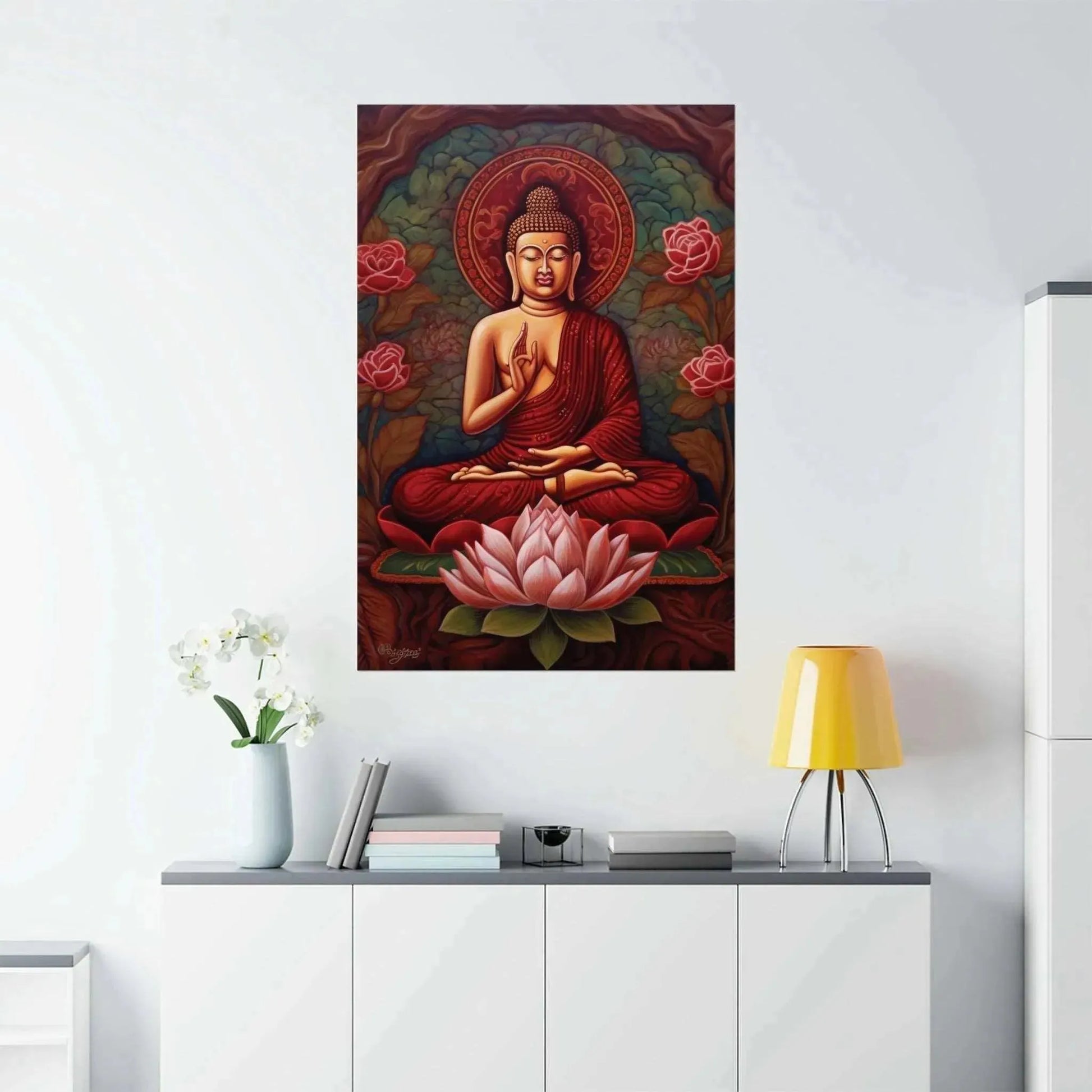 In a tranquil room, an eye-catching painting showcases a meditating figure encircled by pink lotus flowers and elaborate designs. Beneath it, a contemporary white cabinet displays a yellow lamp and "A Striking Abstract" sitting Buddha print from ZenArtBliss.com by Printify, accompanied by a vase with white flowers.